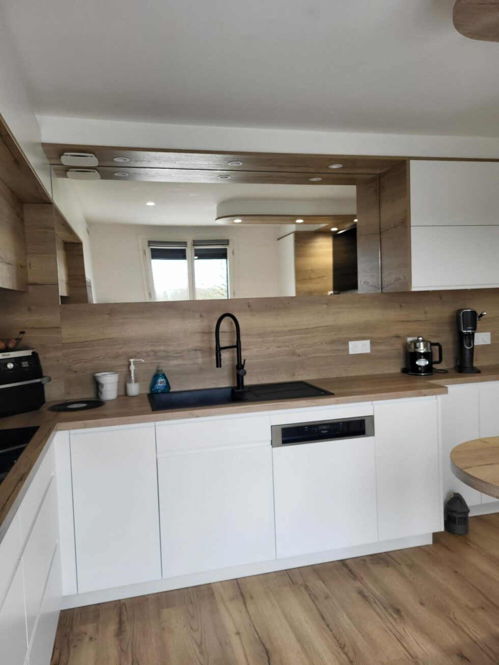 Linéaire évier de la cuisine blanche, robinetterie noire et façades sans poignées